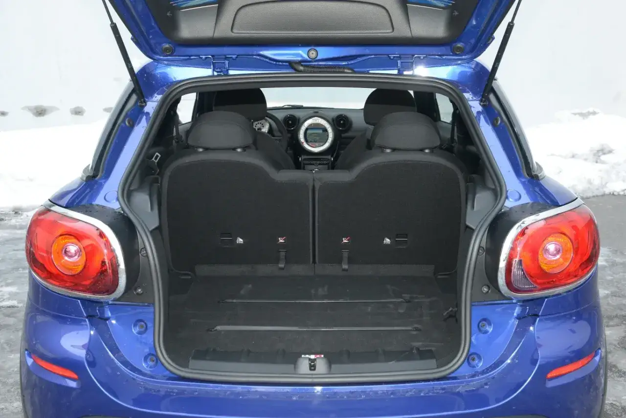 Błękitny mini paceman z otwartym bagażnikiem. Widać tylne siedzenia i przestrzeń bagażową.
