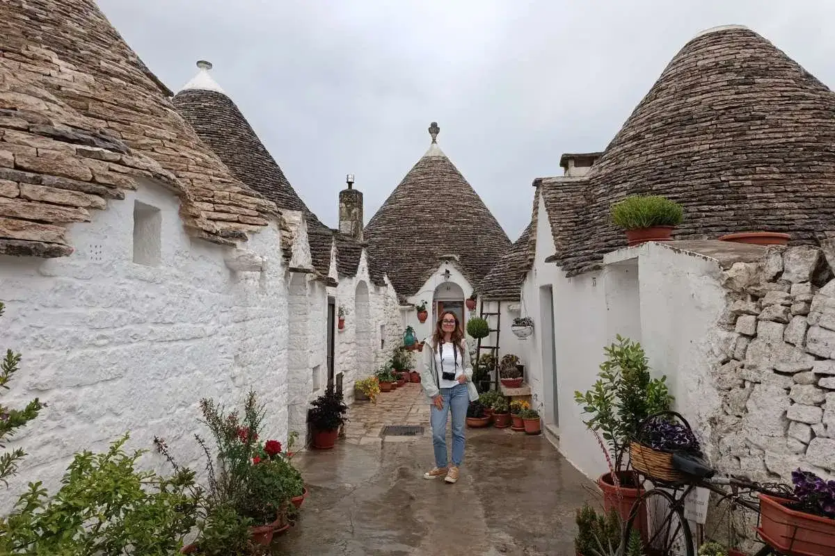 Una donna in un vicolo di trulli, un'idea per i paesi da visitare vicino Alberobello.