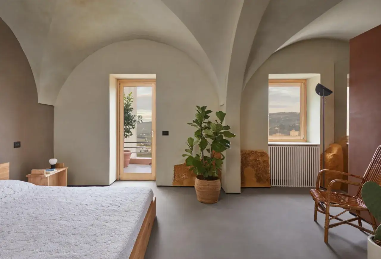 Interno moderno con soffitti a volta, letto, pianta e vista panoramica. Un sogno di case a un euro.