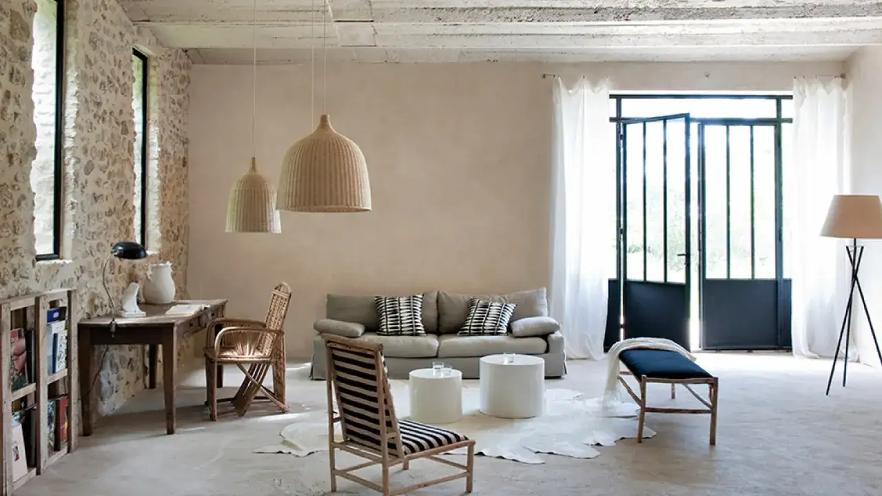 Salon rustique avec murs textur&eacute;s, id&eacute;al pour une peinture &agrave; effet pour mur ab&icirc;m&eacute;. Canap&eacute;, fauteuils en rotin, table et &eacute;tag&egrave;re en bois.