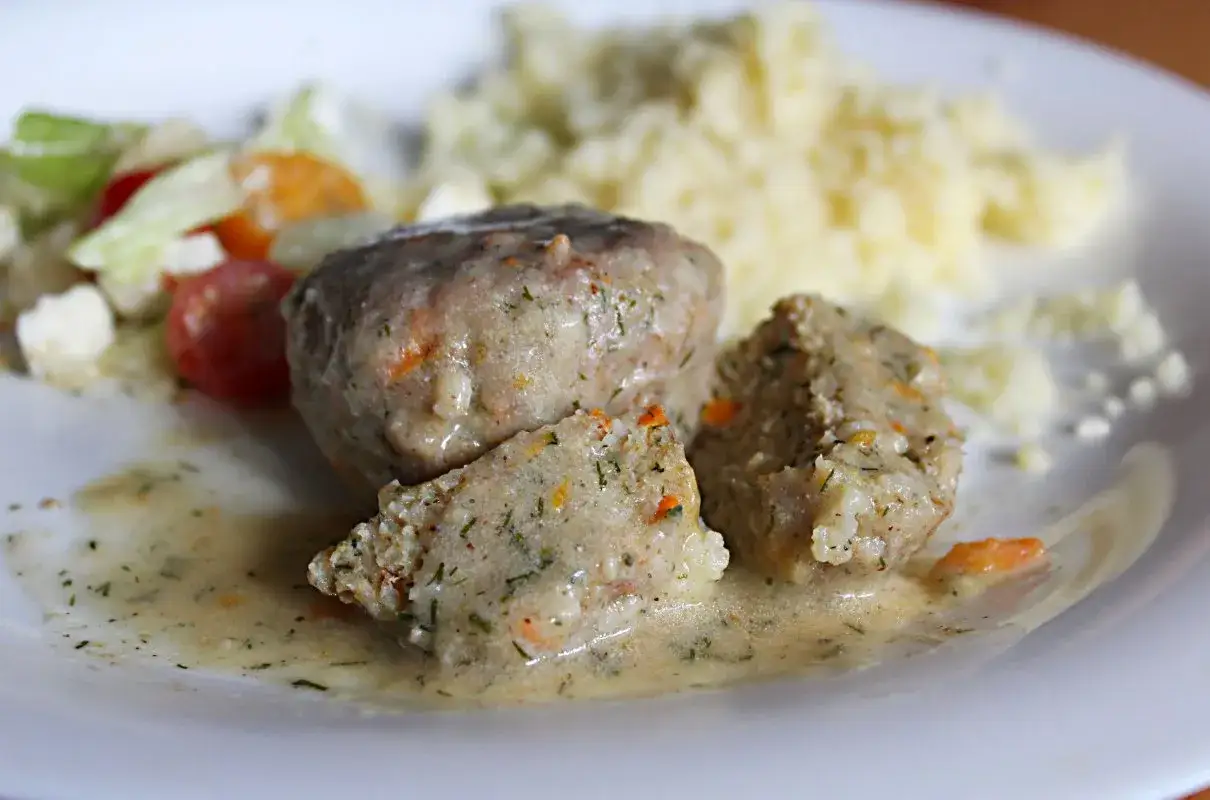 Miękkie pulpety drobiowe w sosie, podane z kaszą i sałatką. Pyszny obiad.