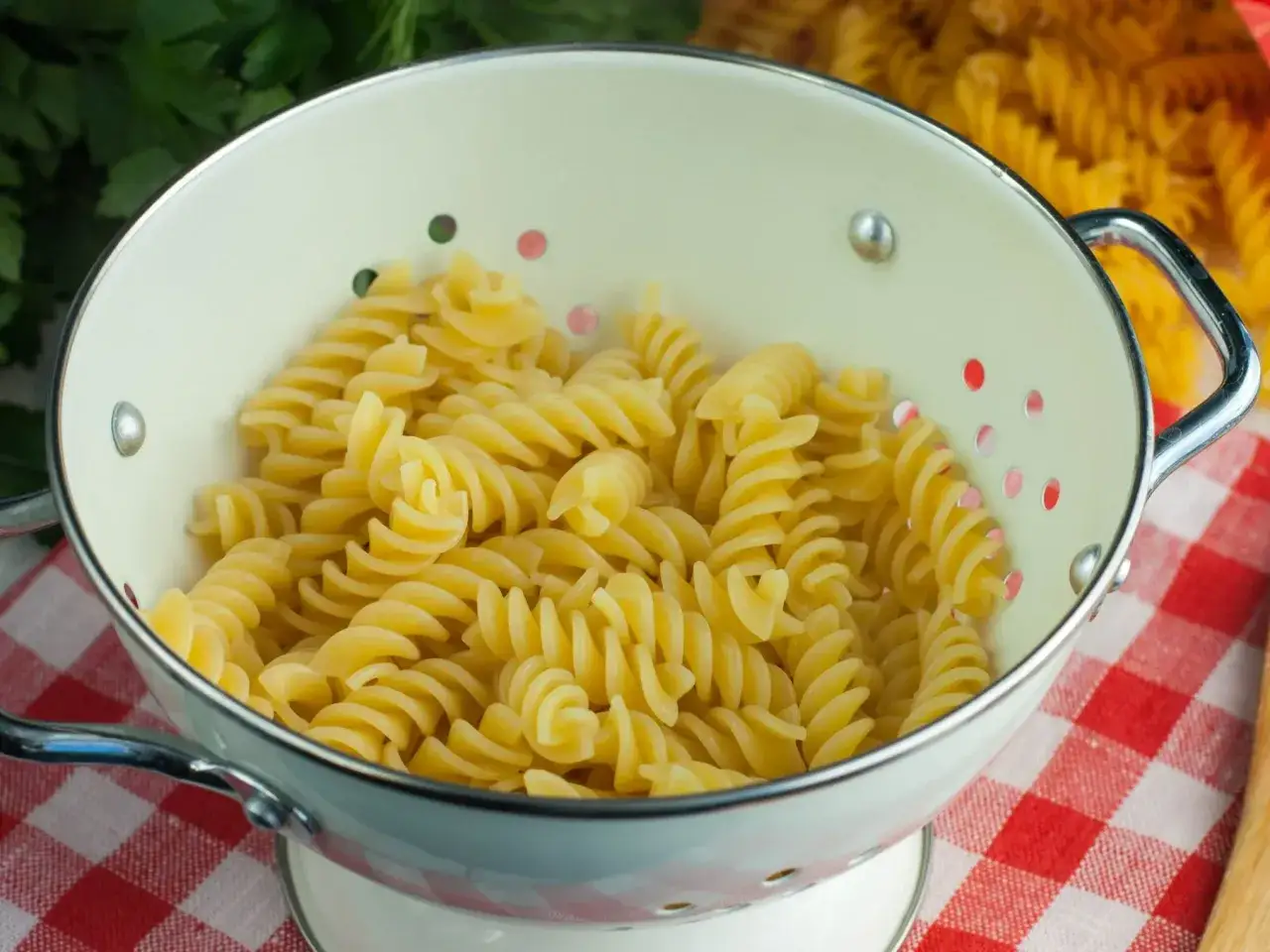 Ugotowany makaron fusilli w durszlaku, gotowy do obiadu. Sprawdź, ile ma makaron ugotowany kcal!
