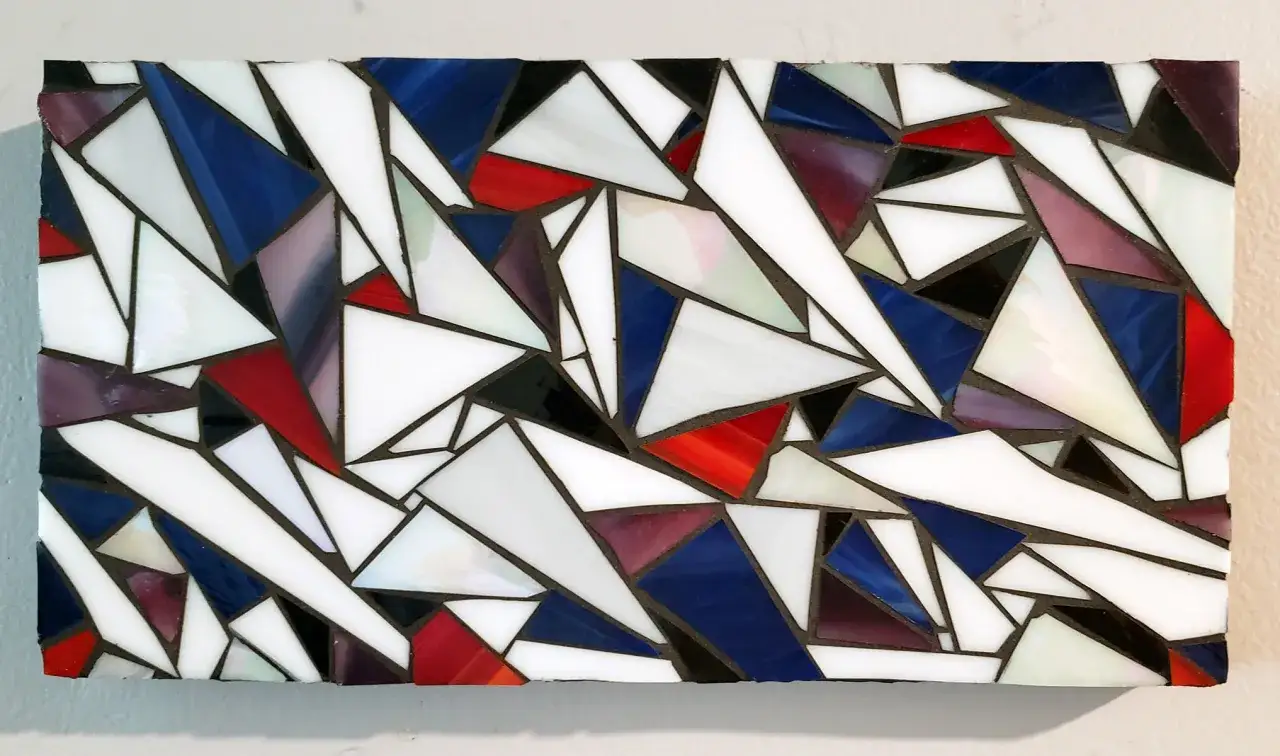 Mosaico geometrico con vetri bianchi, rossi, blu e viola. Un esempio di antitesi visiva, dove forme opposte creano un insieme armonioso.