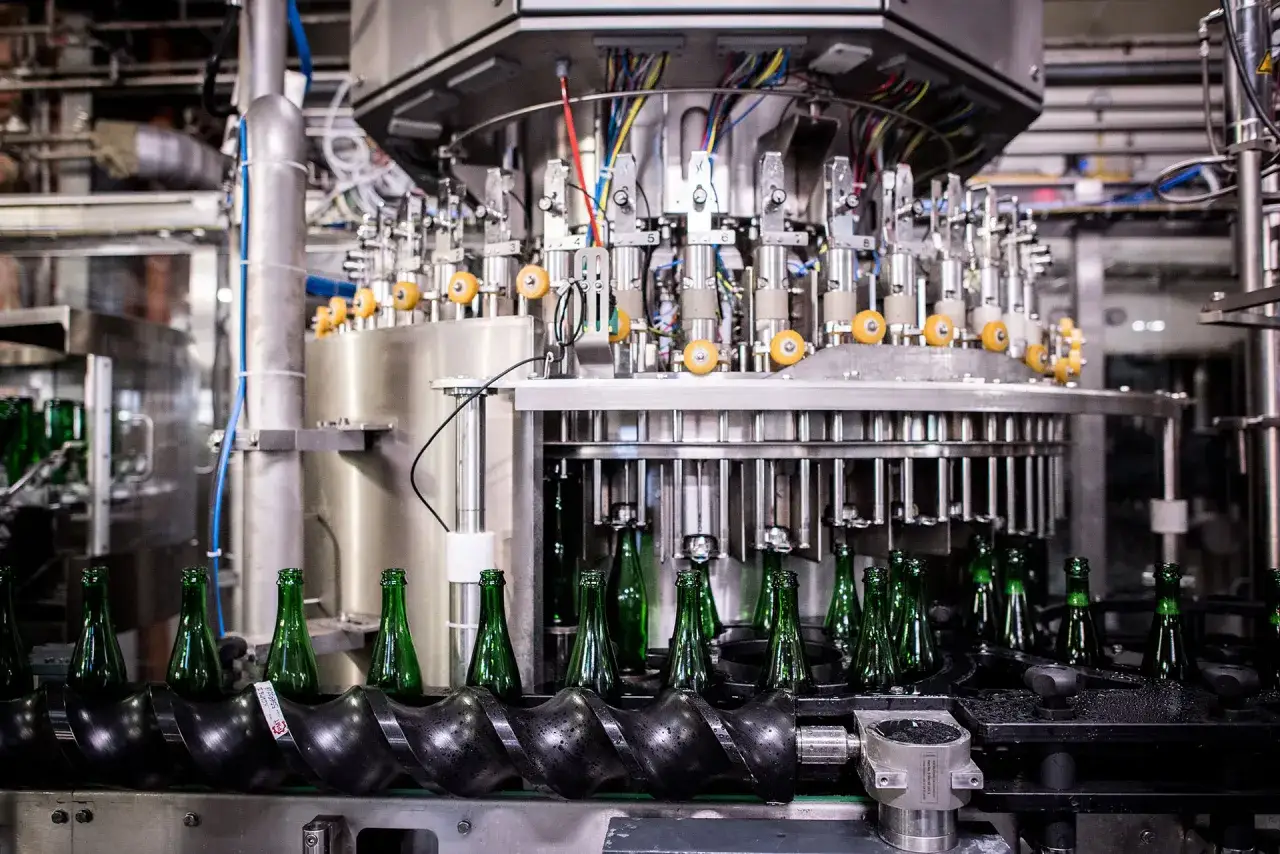 Bottiglie verdi in lavorazione su una linea di imbottigliamento automatizzata. La Brasserie Dupont usa questa tecnologia per produrre la sua birra.