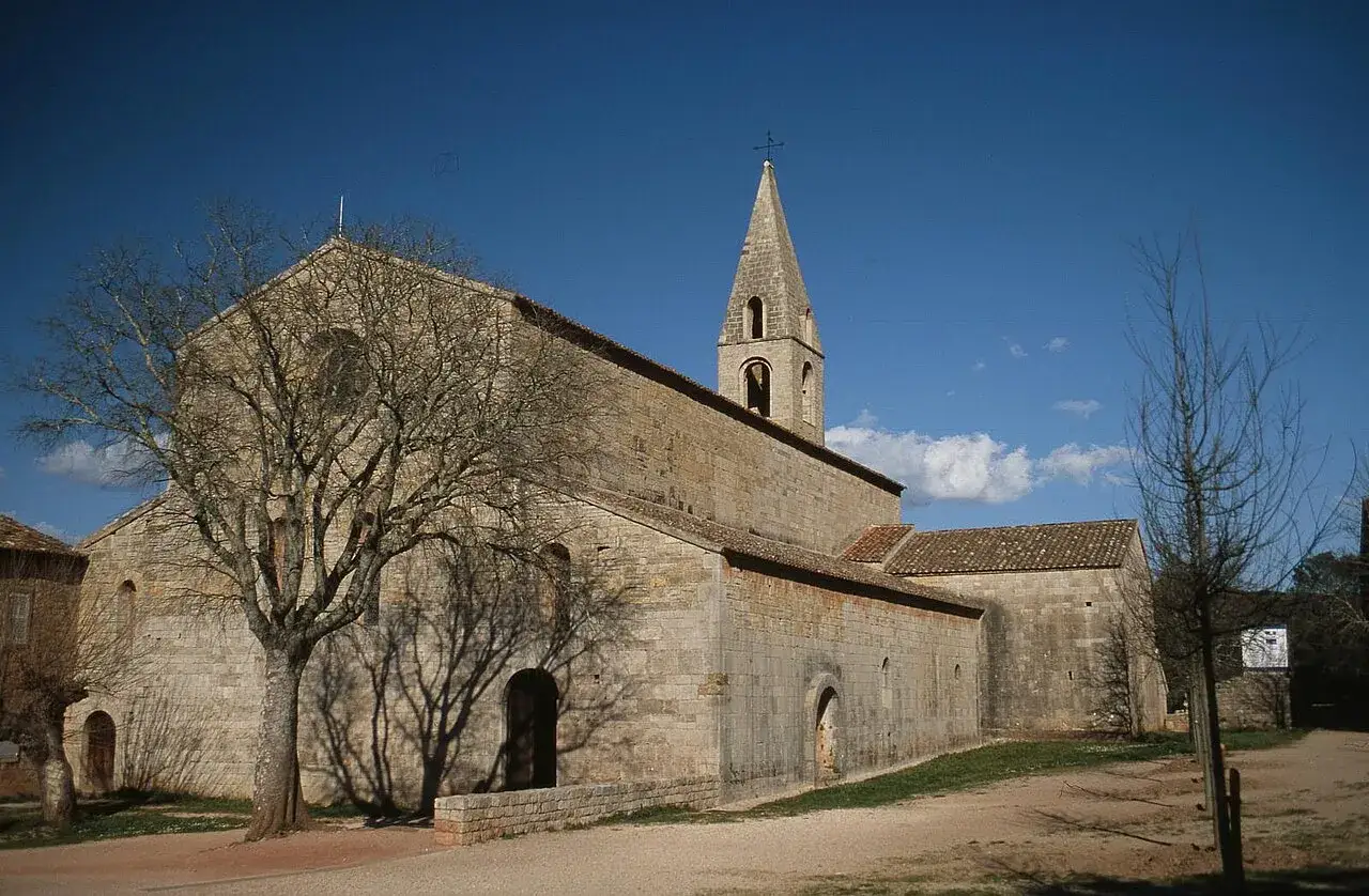 L'abbaye du Thoronet, un joyau de l'art roman, se dresse sous un ciel bleu. Son architecture austère invite à la contemplation. Avis : un lieu à visiter absolument.