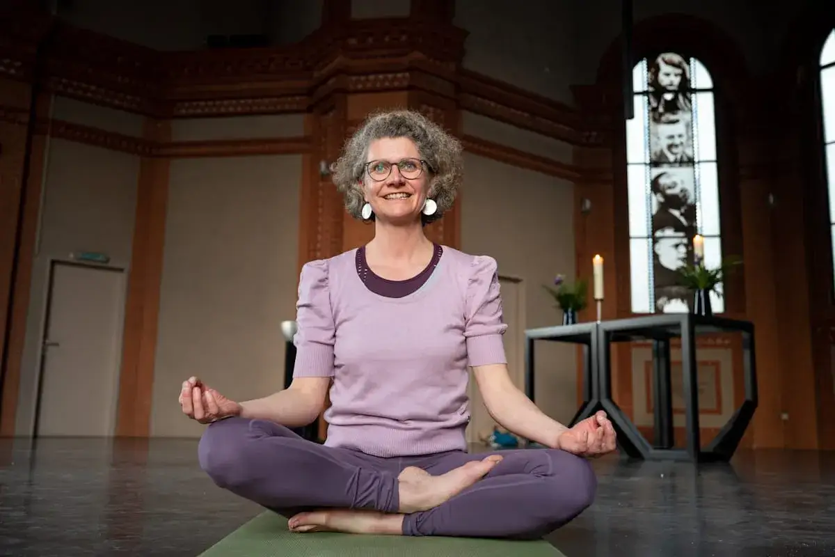 Frau in Meditationshaltung, die Yoga und Christentum verbindet.
