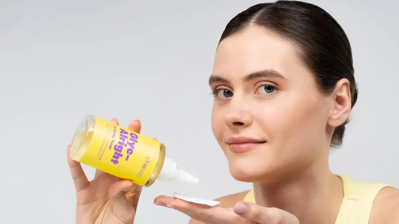 Donna applica un tonico con acido glicolico a casa, per un peeling delicato e una pelle luminosa.