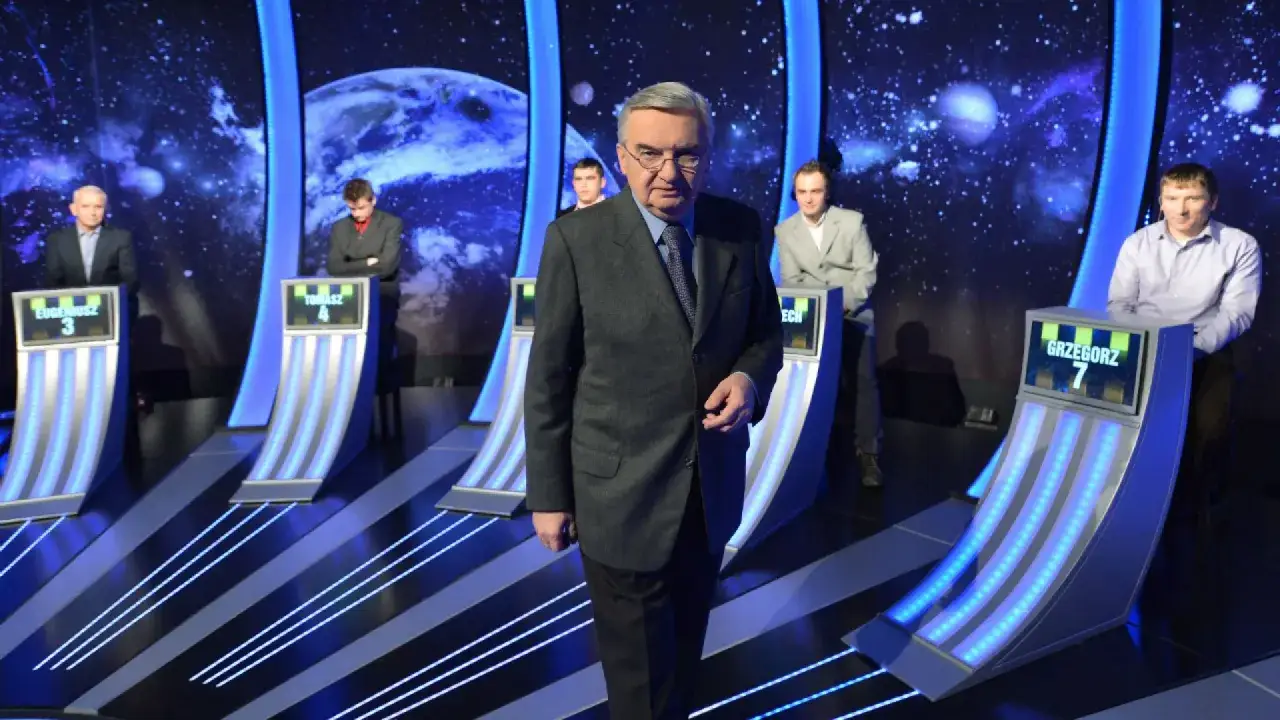 W studio telewizyjnym, wśród kosmicznych dekoracji, prowadzący w garniturze stoi przed uczestnikami. Jeden z dziesięciu od kiedy, kto wygra?