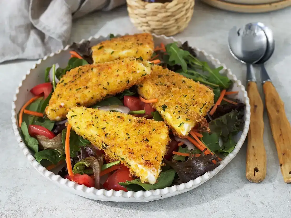 Krispig halloumi på en bädd av gröna blad, tomater och morötter. En riktigt god sallad till maten som passar perfekt till sommaren.