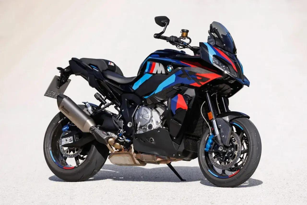 Czarny motocykl BMW M 1000 XR z kolorowymi akcentami M. Sportowy wygląd, sportowy wydech Akrapovič.