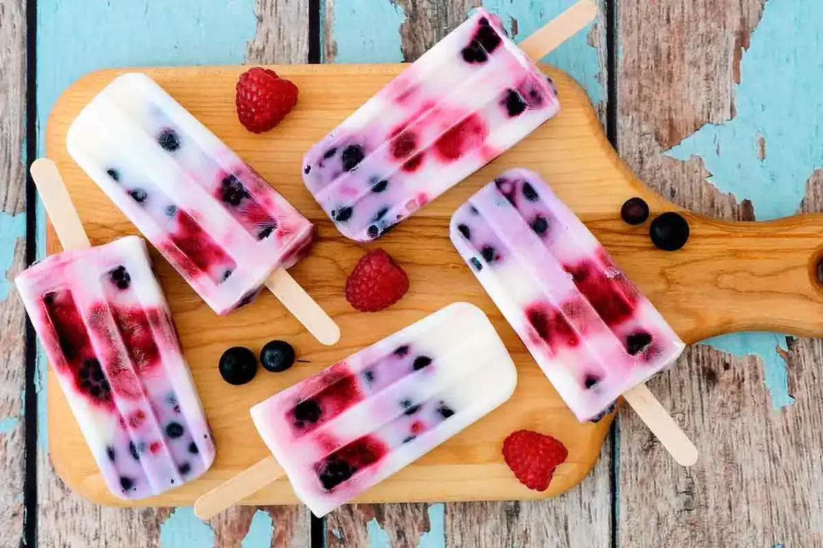 Deliziosi ghiaccioli fatti in casa con frutti di bosco e yogurt, perfetti per un'estate rinfrescante.