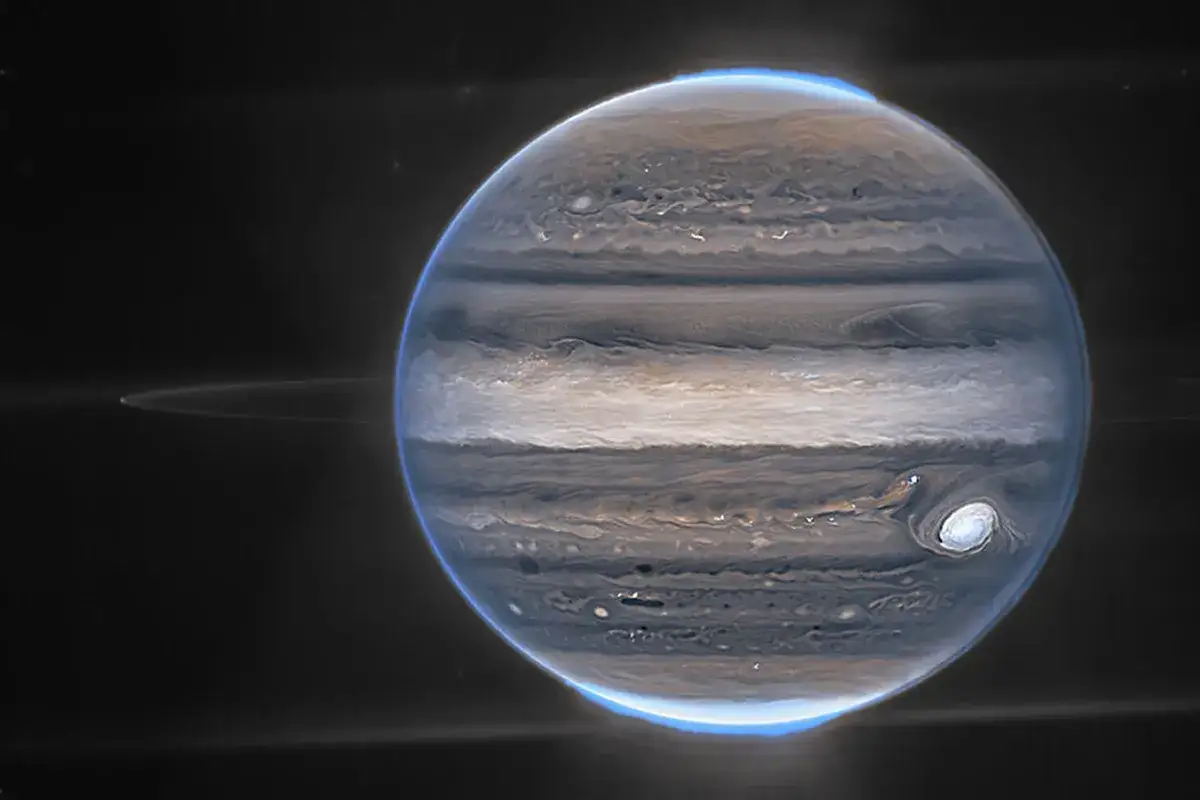 Jupiters virvlande moln och en svag ring syns tydligt runt jupiter. Den stora r&ouml;da fl&auml;cken &auml;r en storm.