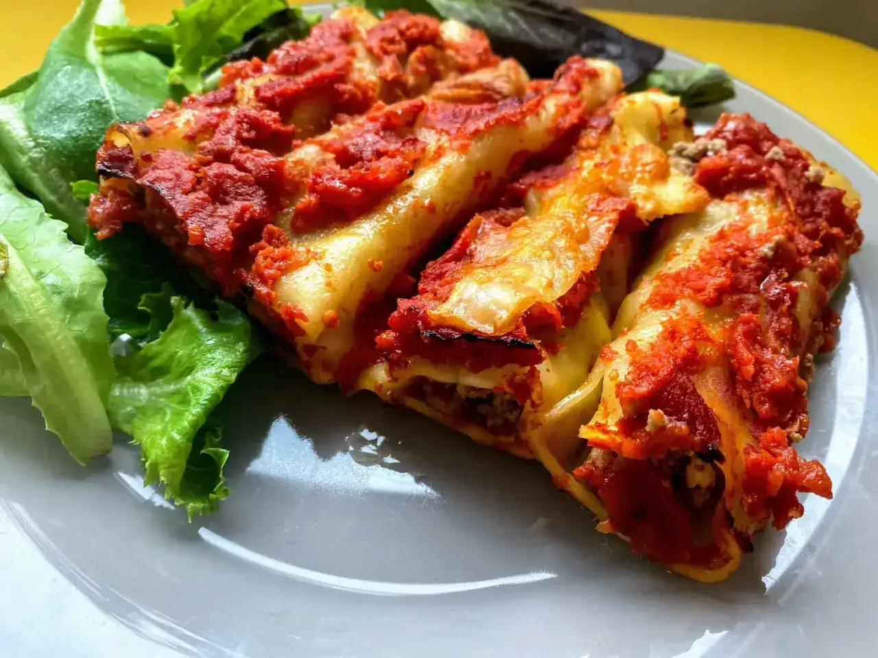 Cannellonis farcis &agrave; la viande, napp&eacute;s de sauce tomate et servis avec de la salade verte. Une recette cannelloni qui met l'eau &agrave; la bouche.