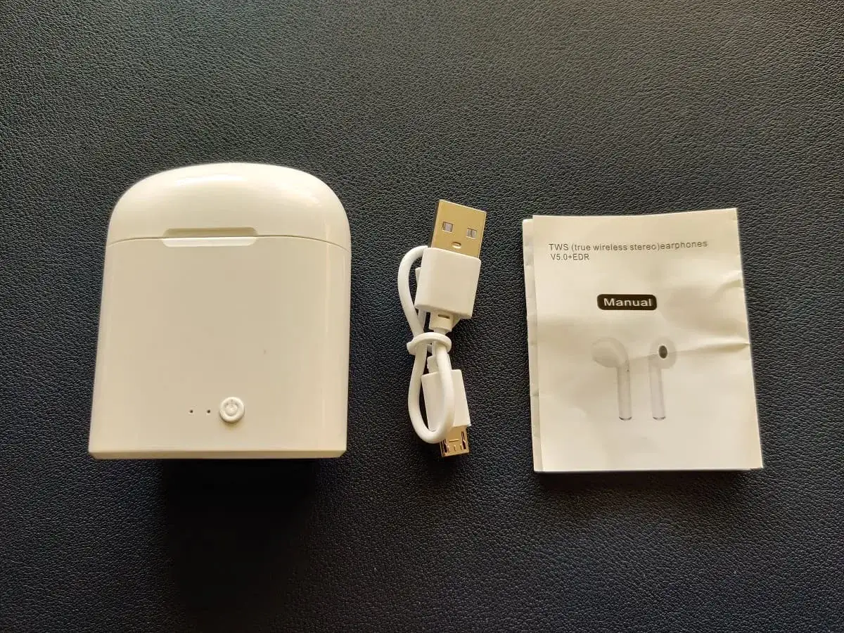 Zestaw i7s TWS: białe etui, kabel USB i instrukcja obsługi słuchawek bezprzewodowych.