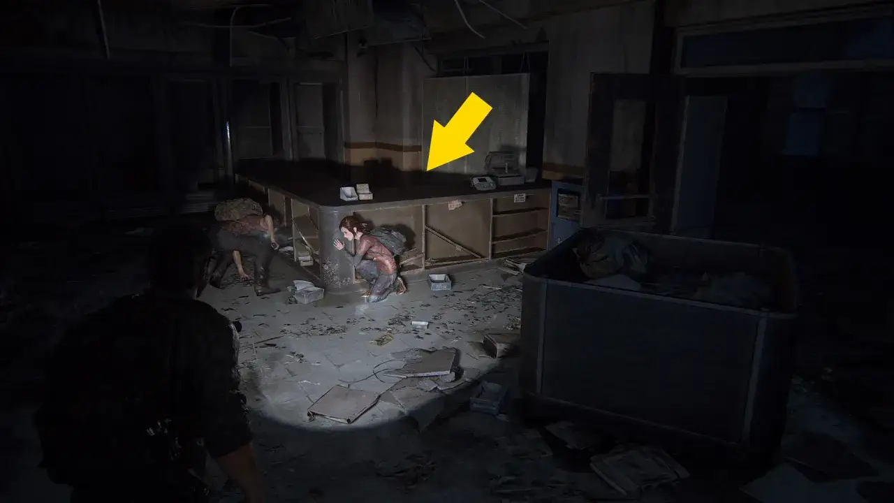 Ellie se agacha cerca de una caja fuerte en The Last of Us 1, mientras Joel la cubre.