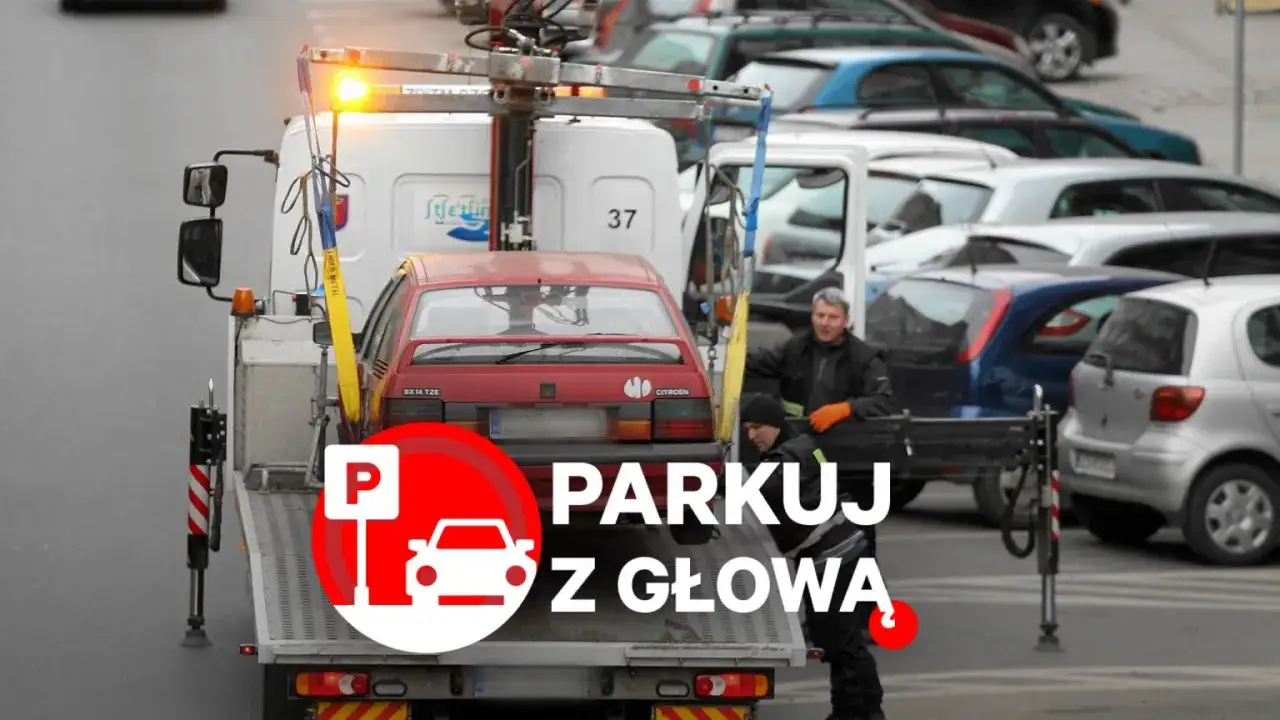 Holowanie czerwonego Citroena. Kierowca z pomarańczowymi rękawicami i pomocnik. Napis