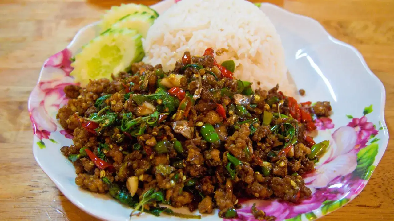 W&uuml;rziges Hackfleisch mit Thai-Basilikum und Reis, ein authentisches Gericht nach original Thai Rezepten. Dazu Gurkenscheiben.