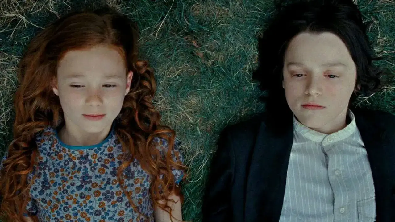 Młoda Lily Evans, matka Harrego Pottera, leży obok młodego Severusa Snape'a na trawie.