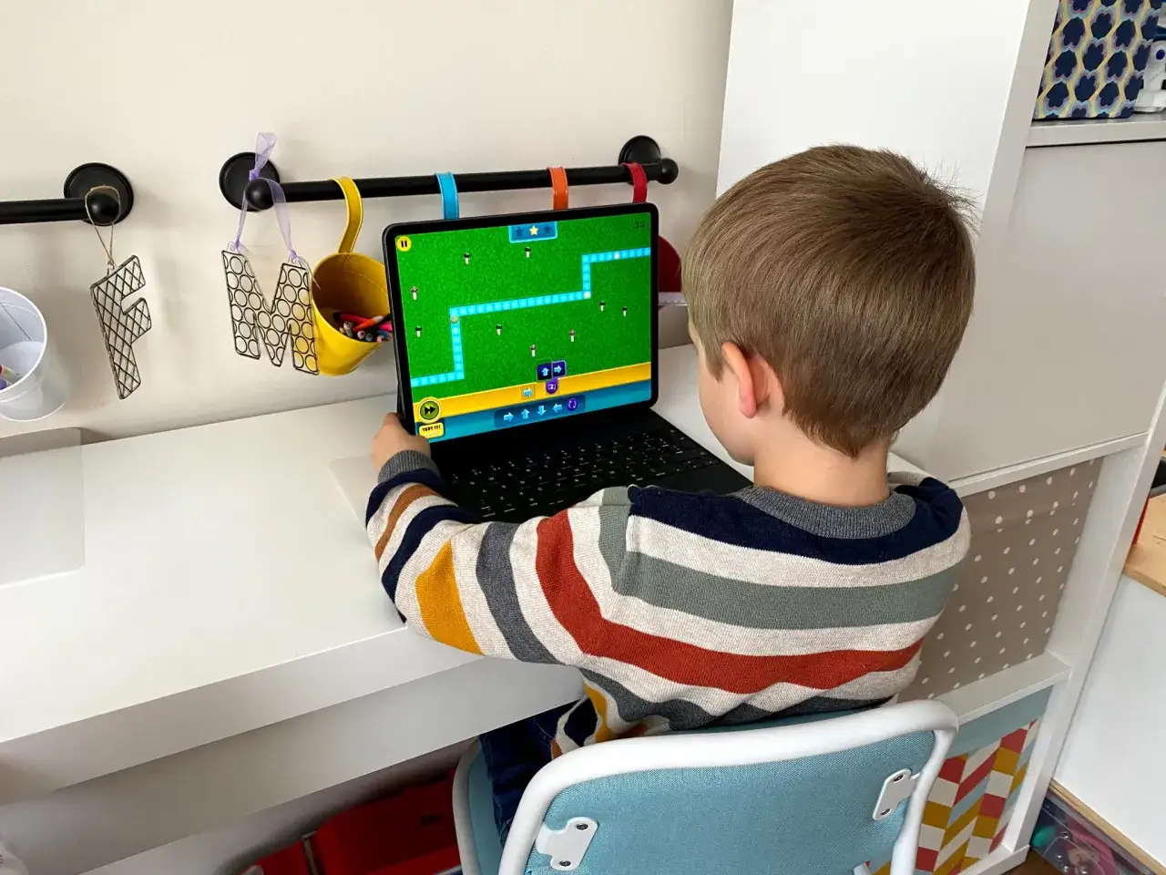 Chłopiec uczy się kodowania do druku, rozwiązując zadanie na tablecie.