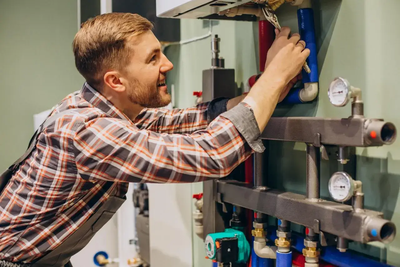 Fachowiec wykonuje serwis Saunier Duval, naprawiając instalację hydrauliczną kotła.