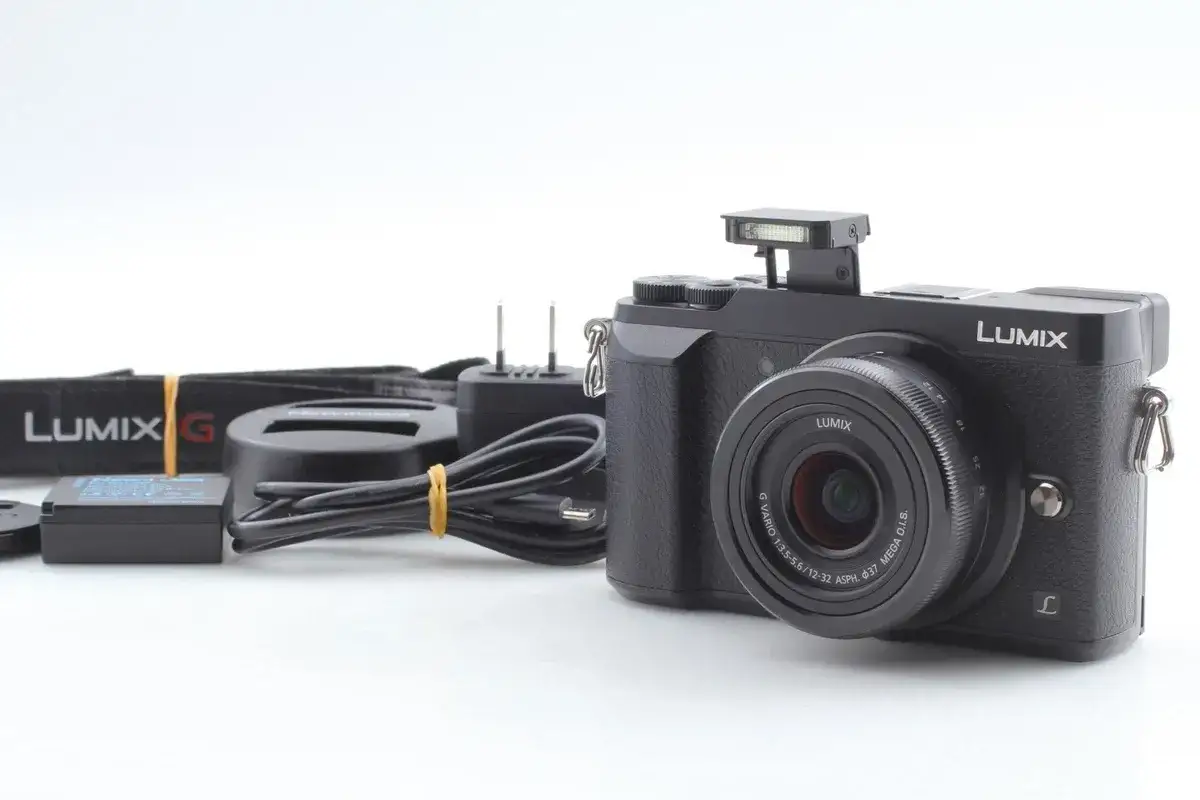Fotocamera Lumix gx80 nera con obiettivo, batteria, caricabatterie e tracolla.