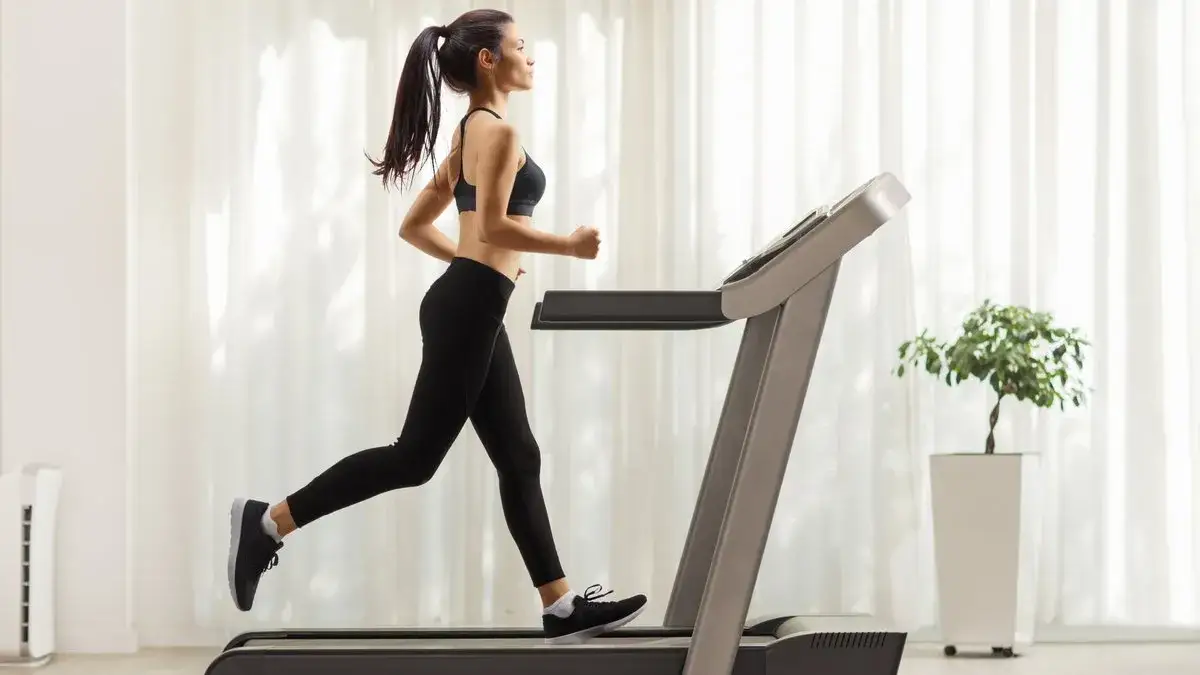 kobieta biegnąca na bieżni, trening cardio