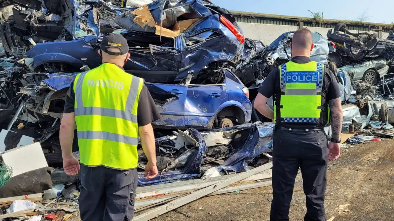 Police investigate a junkyard of crushed cars, a stark reminder of why people steal catalytic converters for their valuable metals.