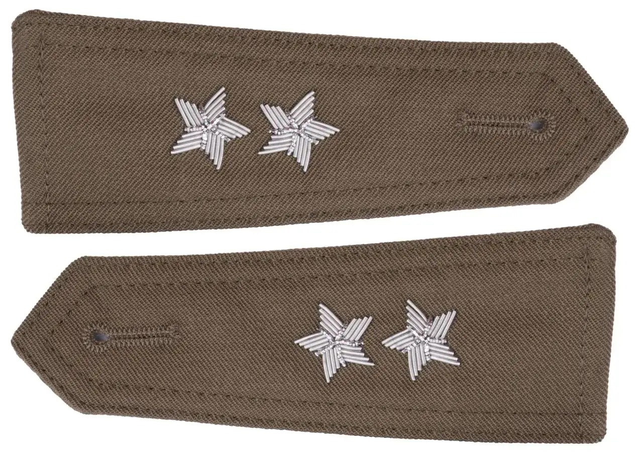 Dwa naramienniki w kolorze khaki, każdy z dwoma srebrnymi gwiazdkami. Symbolizują stopień podporucznika.
