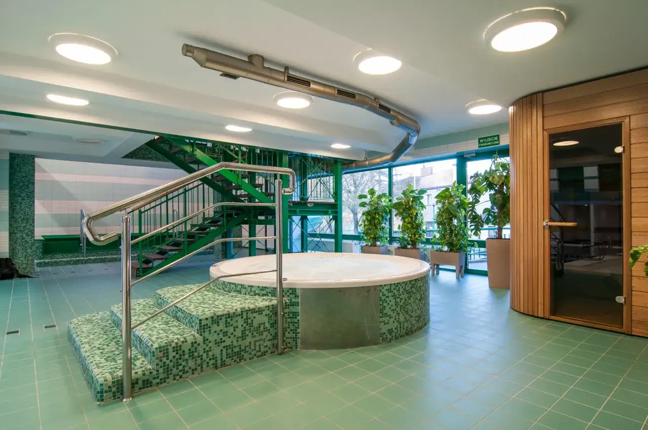 Relaks w basenie w Bieruniu Starym: jacuzzi, zielone schody i sauna.