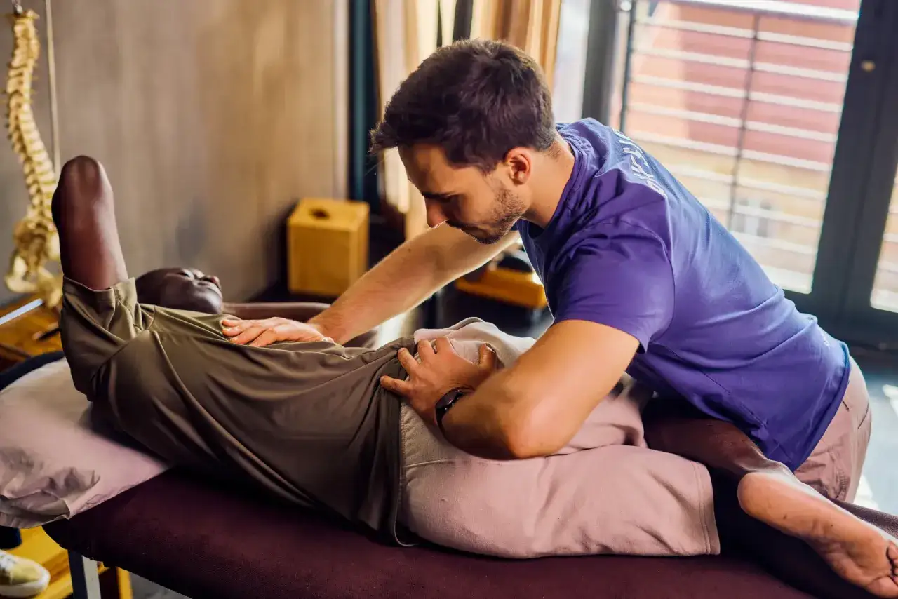Un terapeuta realiza masoterapia que es una t&eacute;cnica de relajaci&oacute;n y alivio muscular. Un hombre recibe tratamiento en su abdomen.