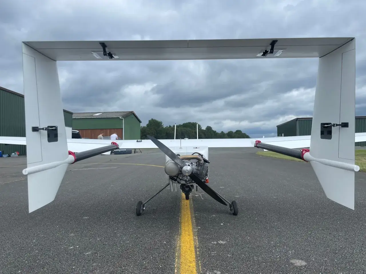 Ein Flugzeug mit Propeller und zwei Heckflossen steht auf einem Rollfeld. Bereit für den Flug, vielleicht für den Erwerb des STS Drohnenführerscheins.