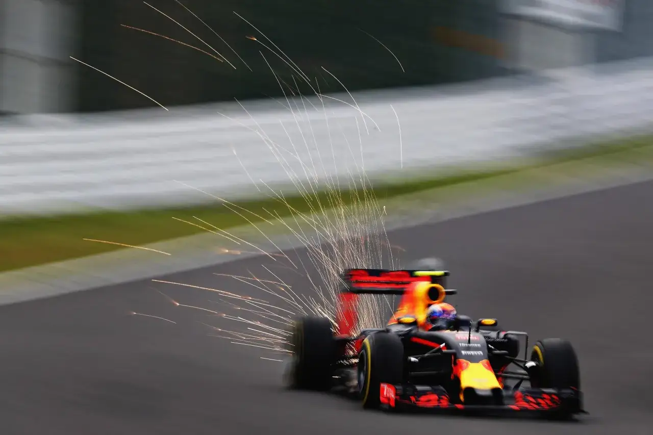 Ein Formel 1 Wagen rast mit Funkenflug über die Strecke. Die Beschleunigung von 0 auf 100 ist hier spürbar.