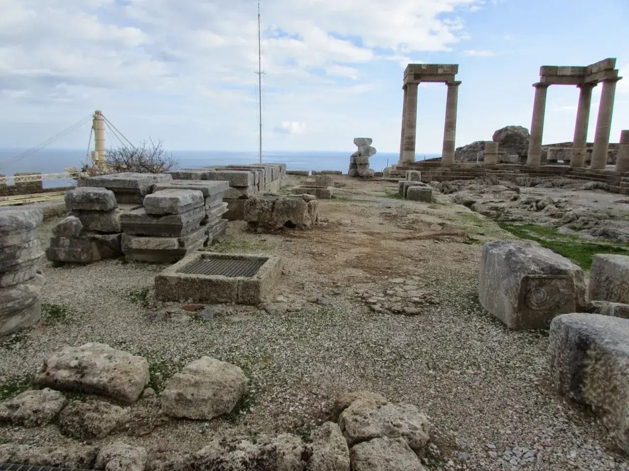 Starożytne ruiny na Rodos, w tym imponujące kolumny i kamienne bloki, świadczą o bogactwie historycznych atrakcji miasta.
