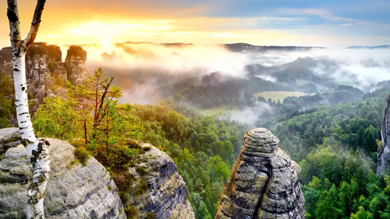 Mglisty poranek nad skalnymi formacjami w Niemczech. Widok z góry na lasy i doliny, idealne miejsce na via ferrata Niemcy.