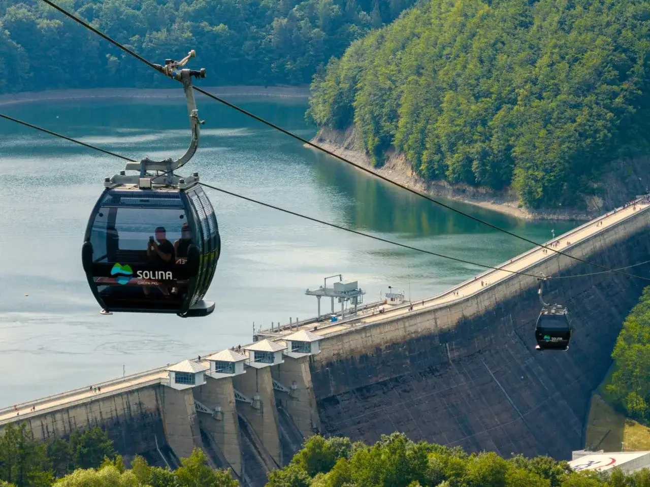 Kolejka gondolowa nad zaporą w Solinie, niczym rollercoaster, dostarcza niezapomnianych widoków na jezioro i lasy.