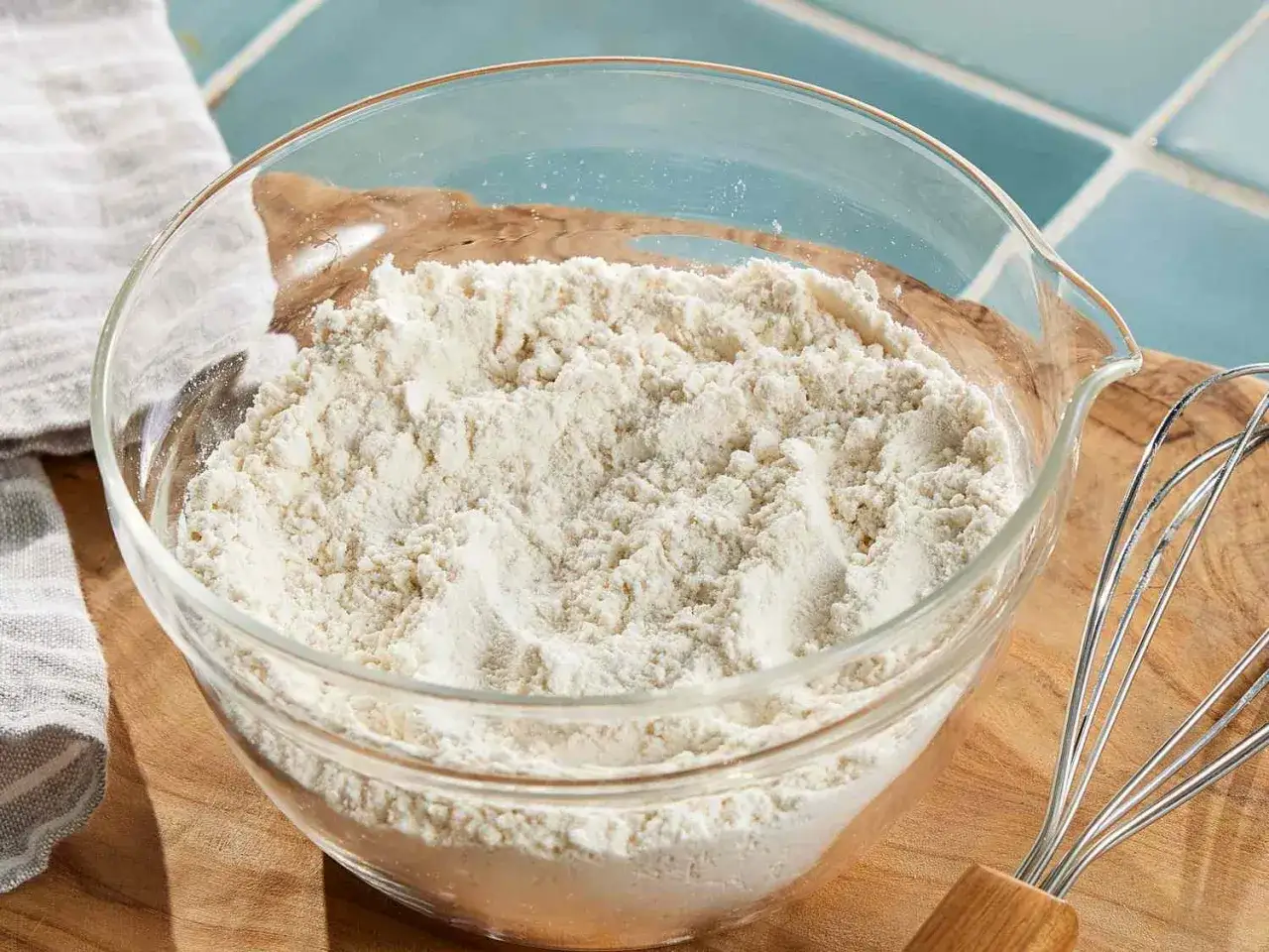 Schüssel mit self-raising flour, bereit zum Backen. Ein Schneebesen liegt daneben.
