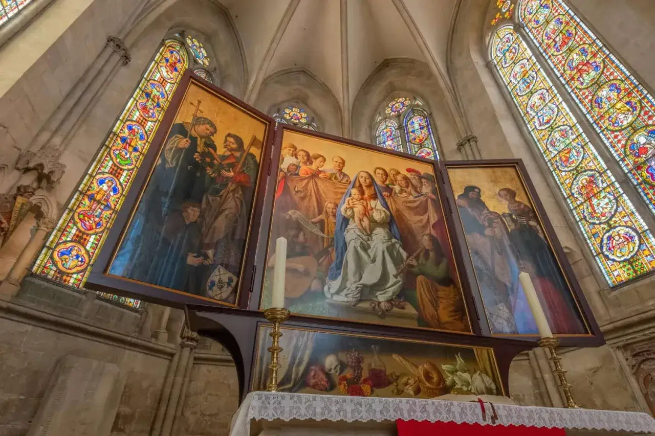 Der Marienaltar im Naumburger Dom zeigt Maria mit Kind, umgeben von Heiligen und Engeln, unter farbenpr&auml;chtigen Glasfenstern.
