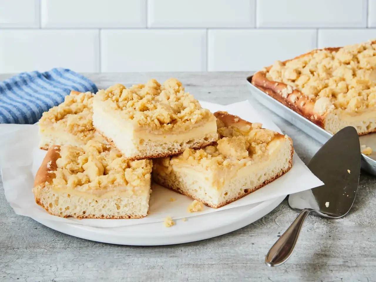 Saftiger Streuselkuchen mit Pudding, auf einem Teller angerichtet, daneben ein Kuchenheber.