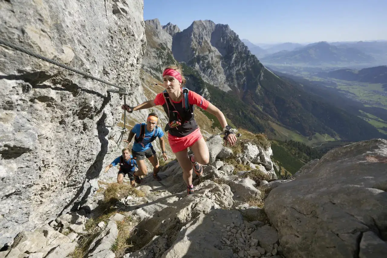 L&auml;ufer auf dem Kaiserkrone trail k&auml;mpfen sich einen steilen, felsigen Pfad hoch. Ein Drahtseil dient als Sicherung.