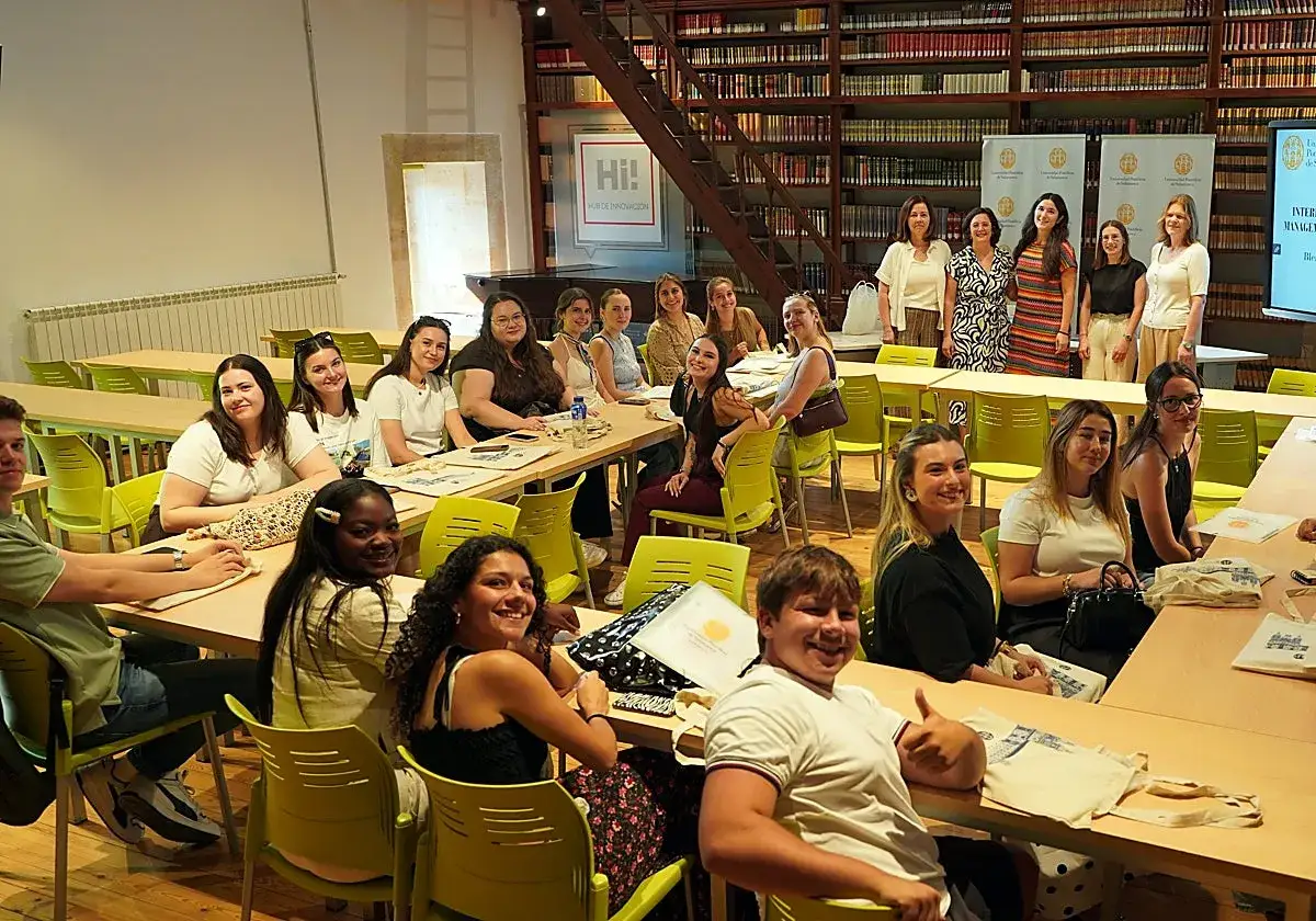 J&oacute;venes sonr&iacute;en en un aula, aprendiendo sobre **Erasmus, qu&eacute; es** y las oportunidades de intercambio.