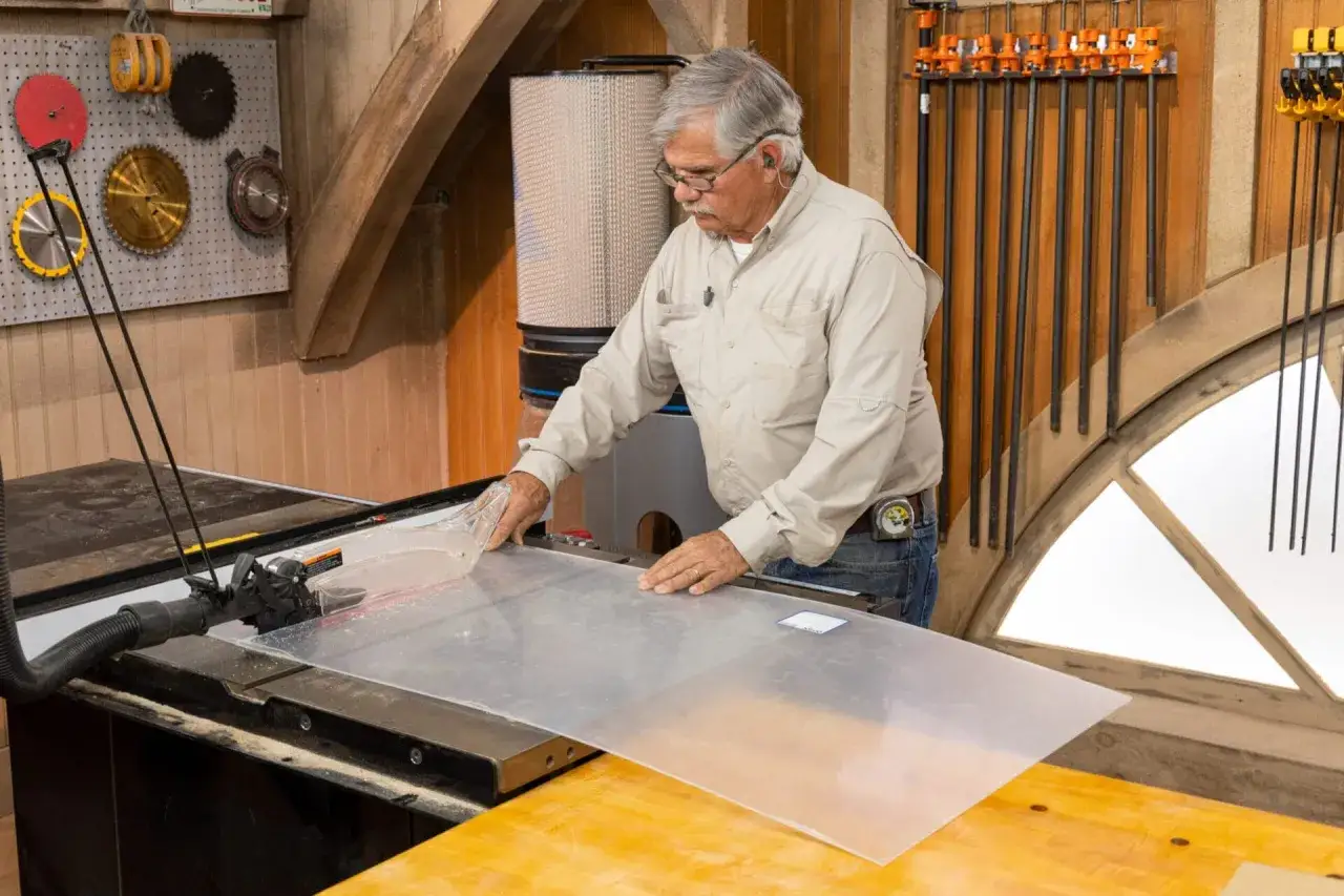 Man uses a table saw to cut plexiglass. This is a common way to cut plexiglass for various projects.