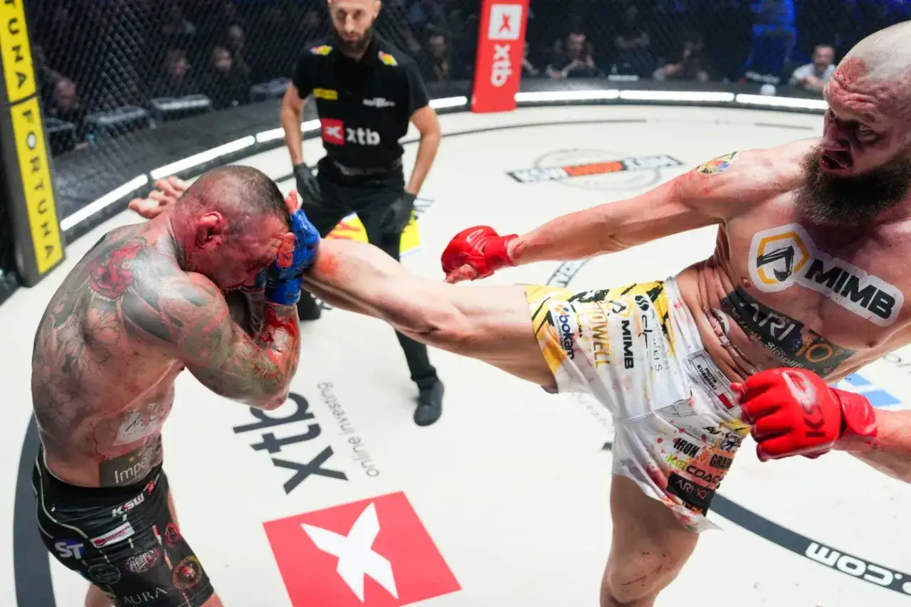 Zacięta walka na KSW. Jeden zawodnik otrzymuje potężne kopnięcie w głowę, krew leje się obficie. Wyniki KSW mogą być brutalne.