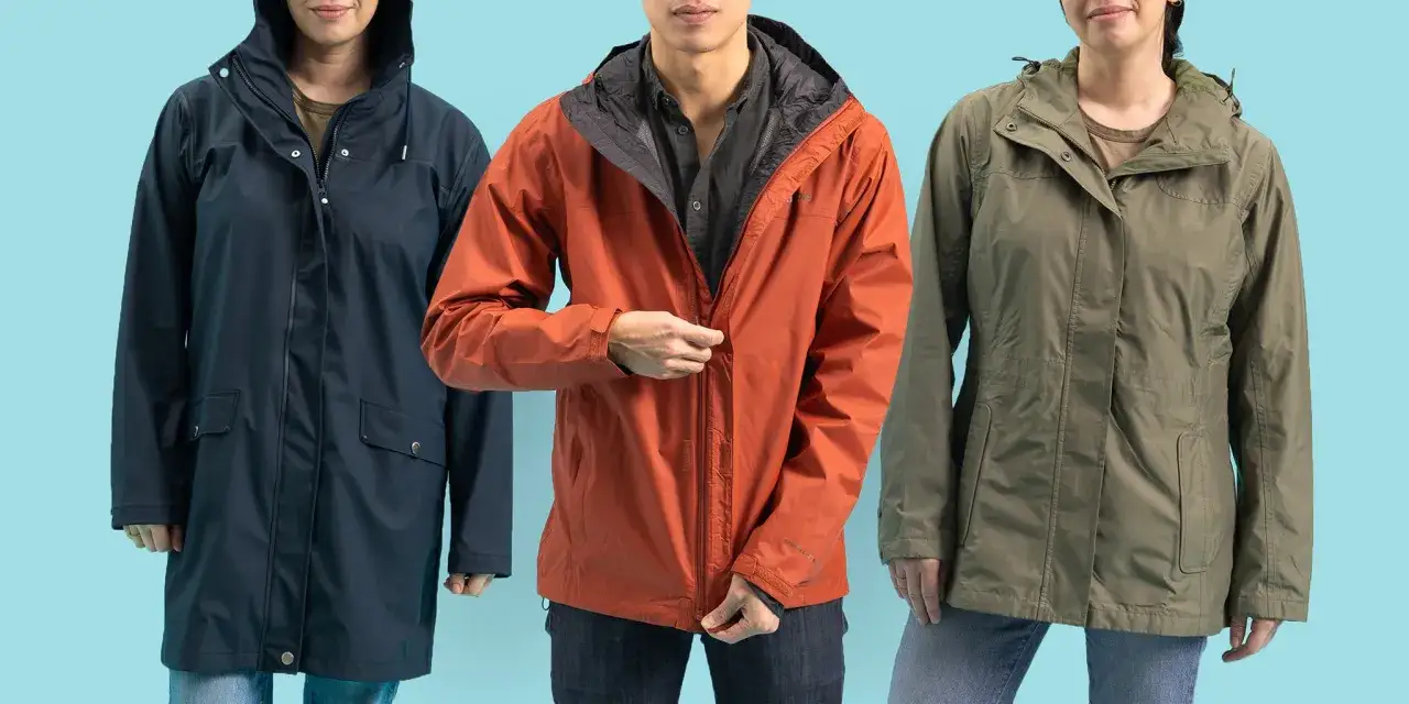 Three people wear raincoats in navy, rust, and olive. These waterproof jackets are made of durable, synthetic fabric to keep you dry.