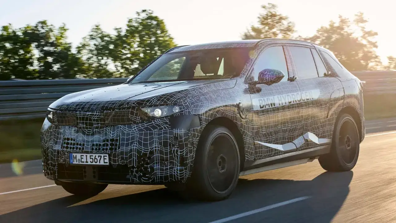 Testowy BMW iX5 Hydrogen na drodze, w kamuflażu z siatką.