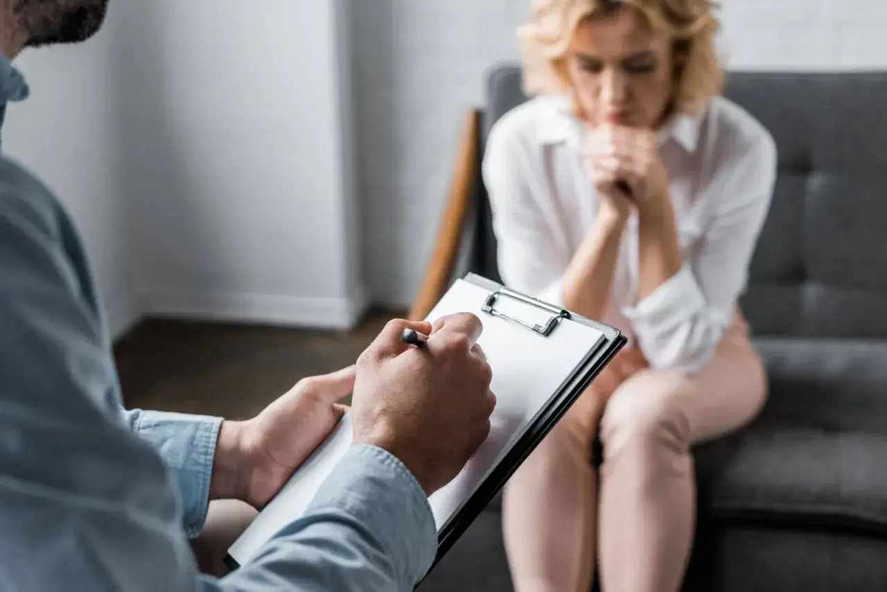 Terapeuta notuje podczas rozmowy z pacjentką. Rozmowa dotyczy tego, jak leczyć depresję.