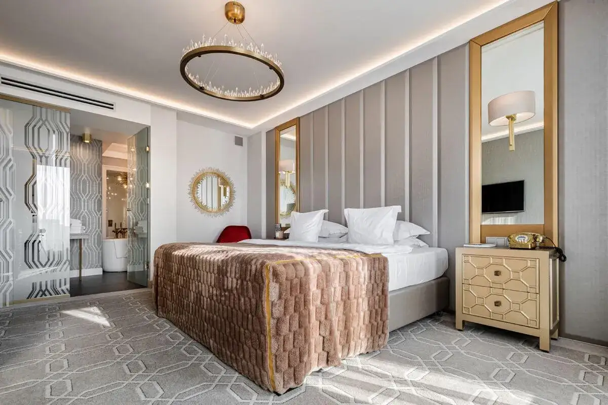 Luksusowy pokój hotelowy z kryształowym żyrandolem, złotymi dodatkami i wygodnym łóżkiem. Prawdziwe gwiazdki w hotelach!
