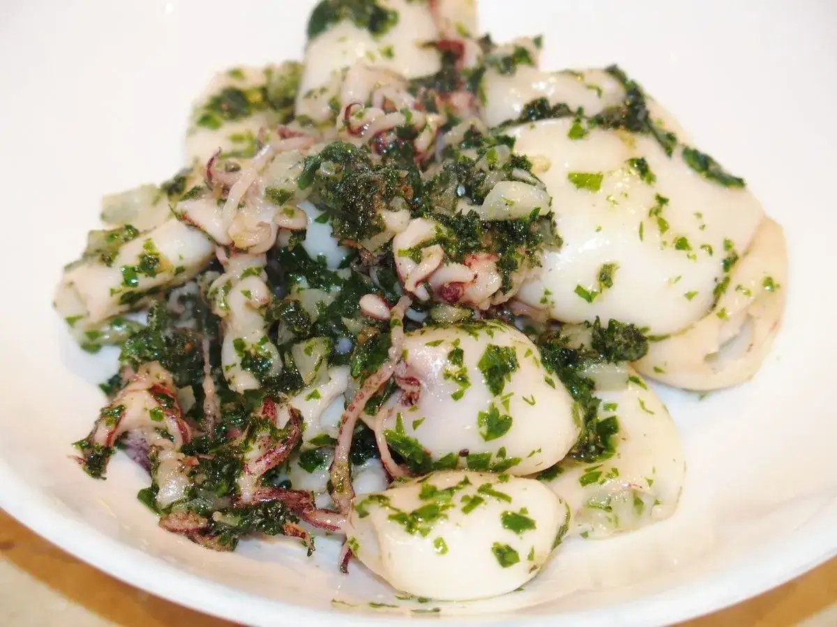 Lamelles d'encornet tendres, poêlées avec persil frais et ail. Un délice simple et savoureux.