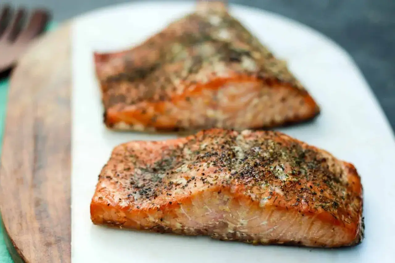 Two seasoned salmon fillets, ready to be enjoyed after learning how to smoke salmon in an electric smoker.