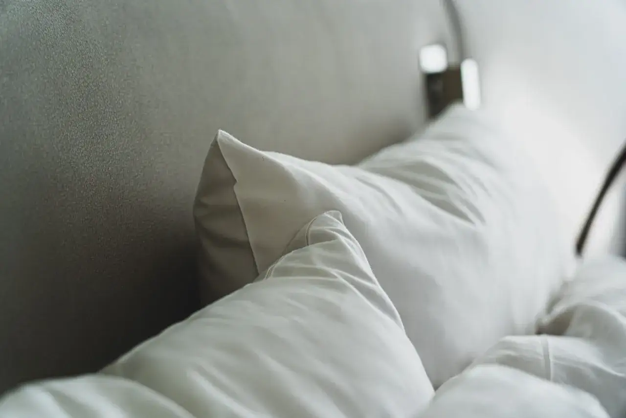 Dos almohadas blancas sobre una cama, listas para un descanso perfecto. La medida almohada cama 135 es ideal para esta cama.