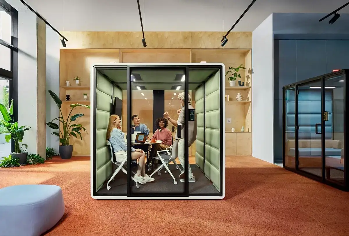 Een team vergadert in een geluiddichte pod, ideaal voor wie overgevoelig is voor geluid en prikkels. De pod biedt rust en focus.